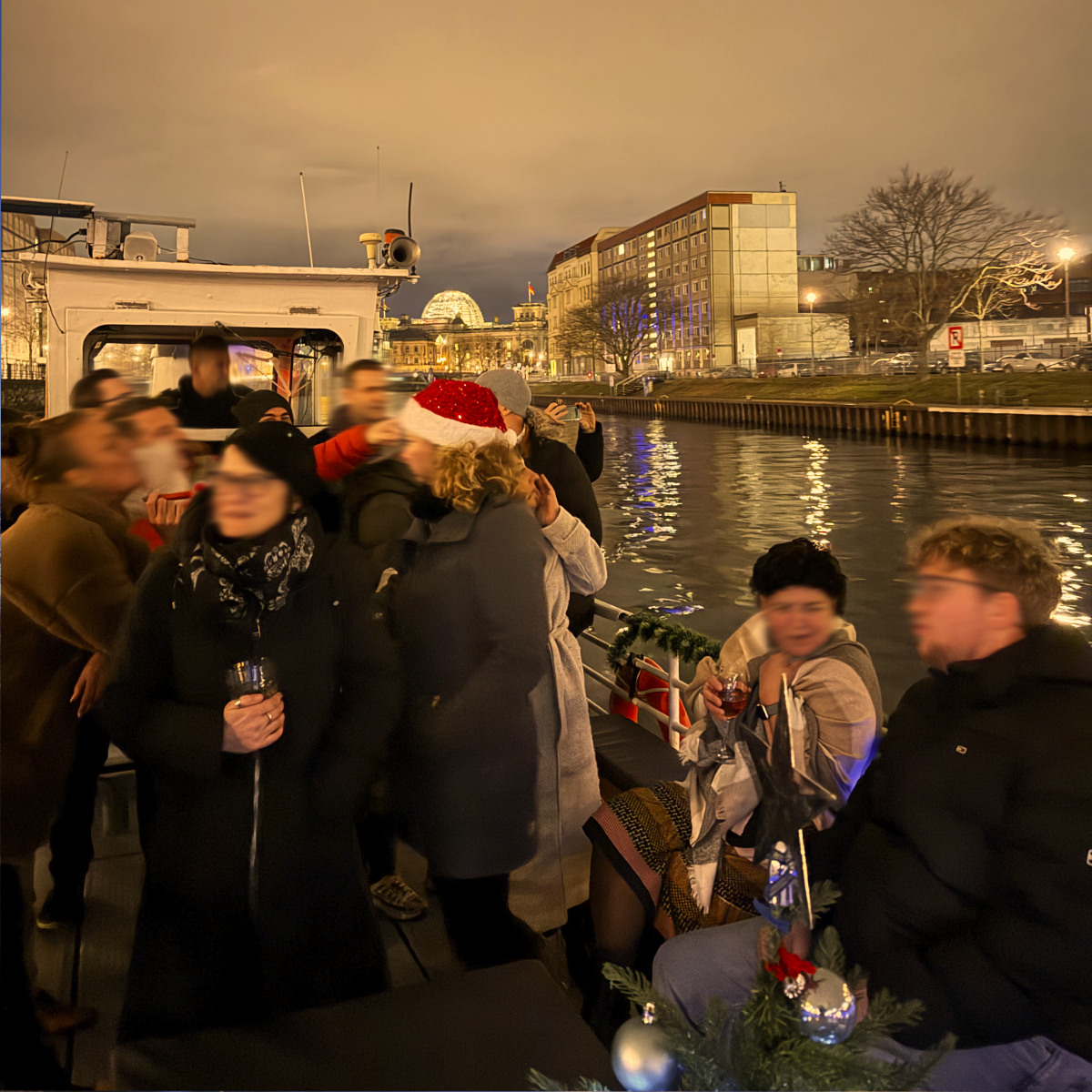 Gäste mit Weihnachtsmützen genießen die Fahrt an Deck der MS Saga